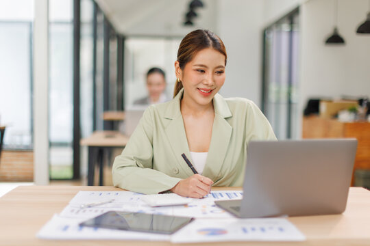 Shot of a asian business female working on laptop computer in her workstation.Portrait of Business people employee freelance online marketing e-commerce telemarketing concept.	