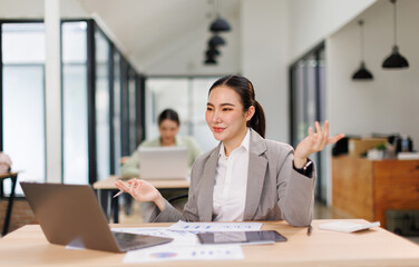 Asian professional analyst business woman sitting at office desk working on laptop thinking on...
