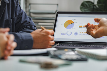 Business professionals analyzing sales data on computer screen with charts and graphs for strategic...