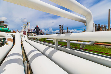 Male worker inspection at steel long pipes and pipe elbow in station oil factory during refinery...