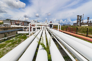 Male worker inspection at steel long pipes and pipe elbow in station oil factory during refinery...