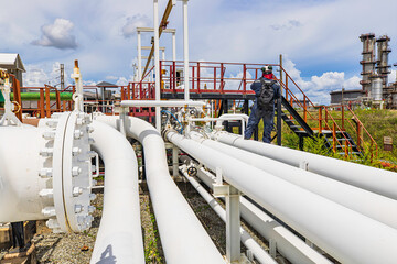 Male worker inspection at steel long pipes and pipe elbow in station oil factory during refinery...