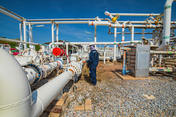Production operator opening ball valve at pipeline oil and gas wellhead remote platform to control...