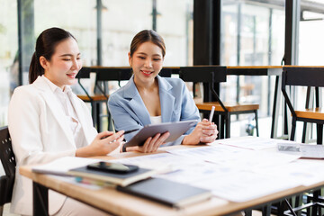 Portrait of Two casual asian business women at work.doing planning analyzing the financial report, business plan investment, finance analysis concept	
