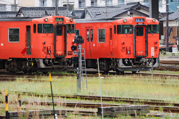 Naklejka premium Two bright red local trains at a train station in Japan