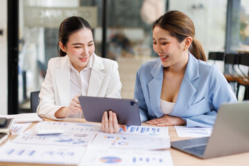 Portrait of Two casual asian business women at work.doing planning analyzing the financial report,...
