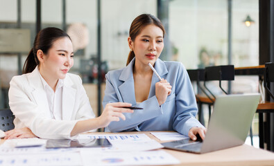 Portrait of Two casual asian business women at work.doing planning analyzing the financial report, business plan investment, finance analysis concept	
