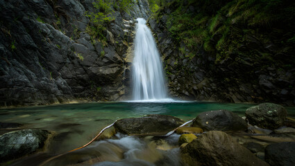 Obraz premium Serene waterfall cascading into emerald pool
