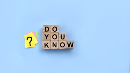 Concept word Do you know on wooden cubes. Question mark on adhesive paper note on blue background....
