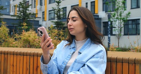 Fashionable young woman creates engaging content for social media by taking selfies with her smartphone, capturing various poses and expressions against the backdrop of a modern urban environment