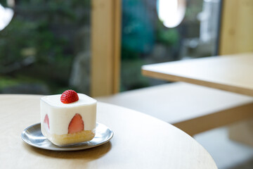 Piece of fresh delicious strawberry shortcake on wooden table.
