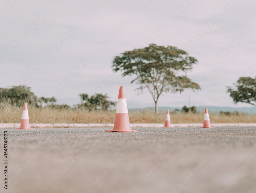 Poster moody driving test setup with training cones on asphalt road in natural soft overcast lighting for s