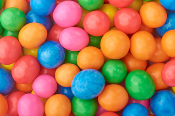 pile of vibrant and colorful milk sweet coated candy or pebbles in full frame, close-up of confectionery food background or backdrop
