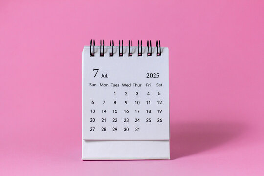 Hello, July 2025. Desktop calendar for planning on a pink background with copy space.