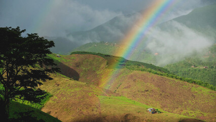 Rainbow over the greenery rainforest mountains and hills