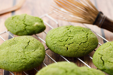 Chewy matcha chocolate chip cookies on cooling rack.