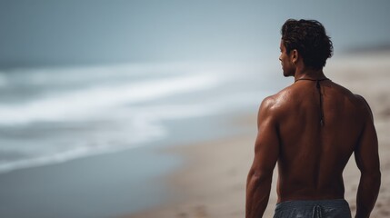 A man standing on a beach looking out at the ocean