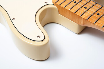 Six-string electric guitar, with a cream-colored wooden body and chrome-plated fittings.