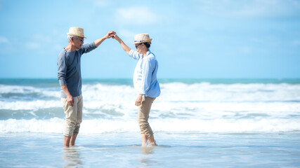 Asian Lifestyle senior couple walking and dancing chill on the beach happy in love romantic and relax time after retirement.  People tourism elderly family travel leisure and activity 
