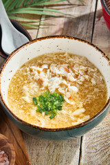 Kani zosui crab soup in rustic bright overhead composition, featuring shredded crab and green onions