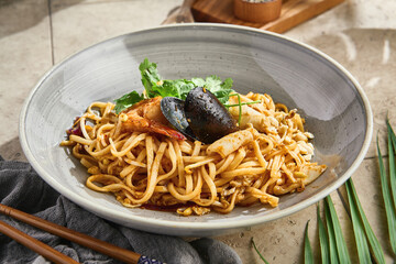 Wok-fried noodles with seafood, bright natural light, overhead restaurant composition
