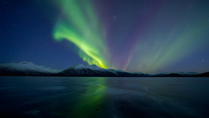 Aurora borealis over frozen lake and mountains