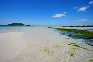 clear shoaling beach and far island