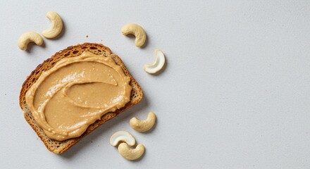 Cashew Butter on Toast with Cashews on a Textured White Surface