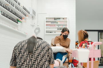 Nail technician manicure or pedicure at nail salon