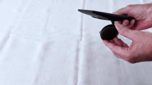 Close-up of hands carefully installing a GPS tracker on a clean white surface-precise movements, clear angles, and a minimalist backdrop highlighting each setup step