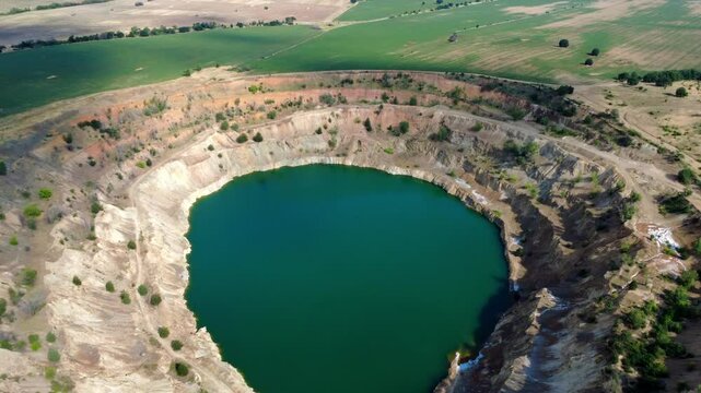 Aerial view of Tsar Asen Mine, Bulgaria &ndash; a former open-pit mine for non-ferrous metals, especially copper. Now transformed into a turquoise lake, it lies amid vivid rock layers and surrounding fields