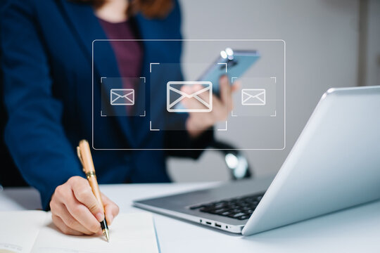 rofessional woman multitasking with smartphone and writing notes, surrounded by email icons