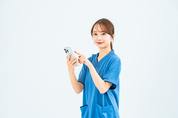 スマホを使うスクラブを着た女性　看護師　介護士