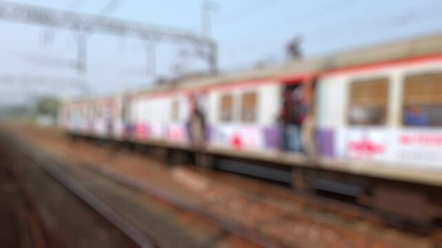 Bokeh view outside of moving suburban passenger train running to Mumbai, Maharashtra, India. Blurred background footage.