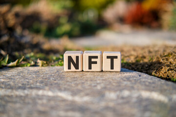 NFT - text on cubes standing on a stone on a natural background