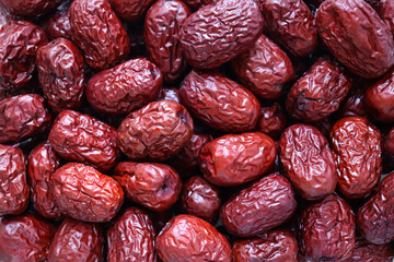 Macro shot of a pile of dried red jujubes.
