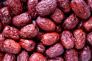 Macro shot of a pile of dried red jujubes.