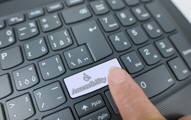 Accessibility key on a gray keyboard. Finger pressing key