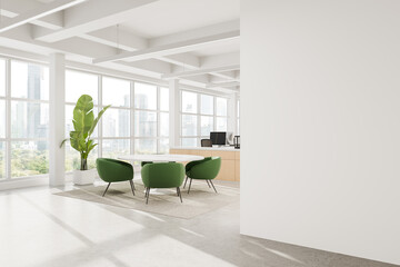 Modern office interior with green chairs, wooden desk, large windows, and blank white wall for...
