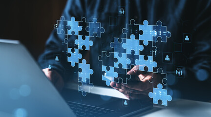 Digital teamwork concept with puzzle pieces representing collaboration and global success, floating above a laptop on a dark modern workspace background.