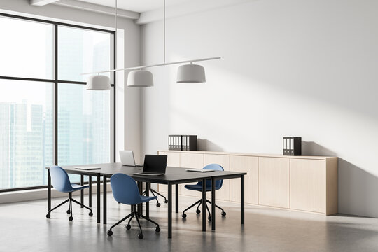 Modern minimalist office interior with large windows and blue chairs in bright workspace setting, featuring clean design and natural lighting. 3D Rendering