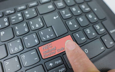 NEC-national electrical code key on a gray keyboard. Finger pressing key