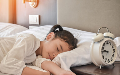 Child sleeping well on bed at bedtime night. Little toddler girl sleeps in bedroom at home, healthy lifestyle of Asian school kid student dreamer asleep enough relaxation at night in bed room hotel