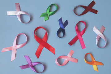 Colorful awareness ribbons representing different causes lying on blue background