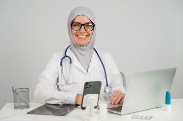 Female doctor in hijab smiling and looking at camera. 