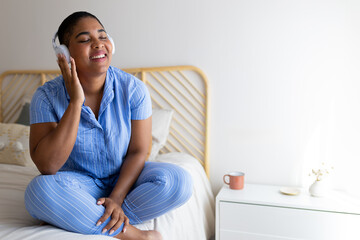 Young woman enjoying music with headphones in bedroom