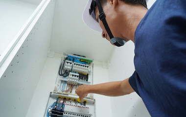 Electrician working checking a switchboard with fuses
