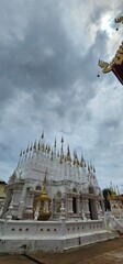 Ornate White Temple Spires Reaching Toward a Cloudy Sky: A Stunning Example of Thai Religious...