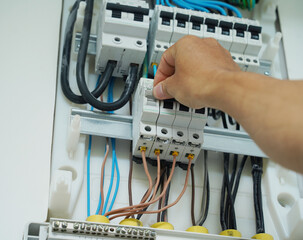 Electrician working checking a switchboard with fuses