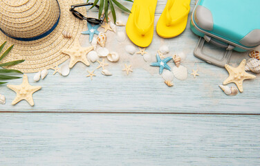 Summer accessories creating a frame on light blue wooden background